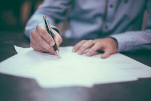 man writing on paper. Christian business leader engaging with team in a collaborative, faith-centered workplace environment, focused on integrity and purpose